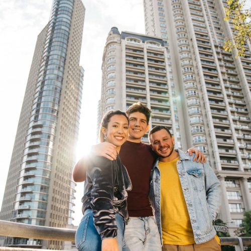 multiracial-young-friends-standing-against-city-buildings